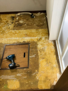 洗面スペースの床（リフォーム前のクッションフロア）をめくった状態