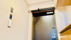 マンション玄関扉の上にある装置により自動扉化した開き戸の写真。マンション玄関の引き戸化ができないときの選択肢